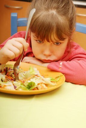 grumpy child eating food