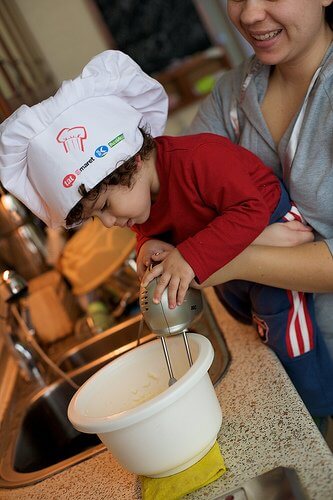 little boy helping mom in kitchen