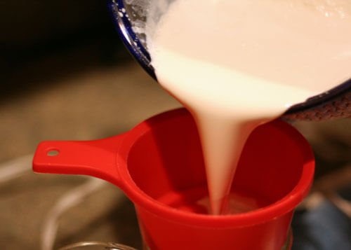 pouring sunscreen into jars