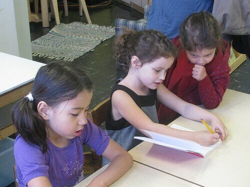 sisters writing in a family gratitude journal at keeperofthehome.org