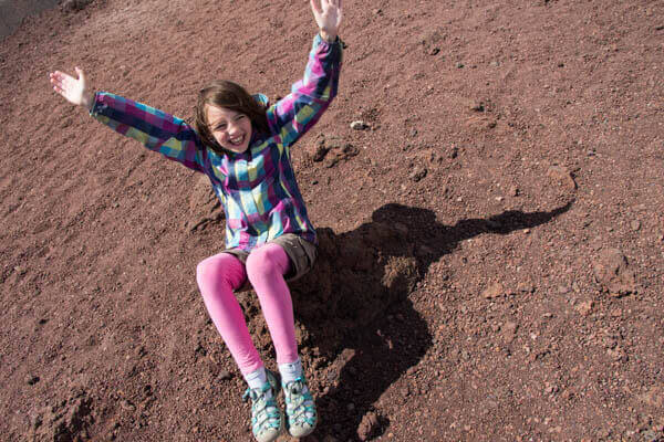 abbie balancing on rock at crater on mount etna
