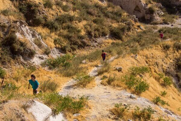 kids running on grassy path at uchisar